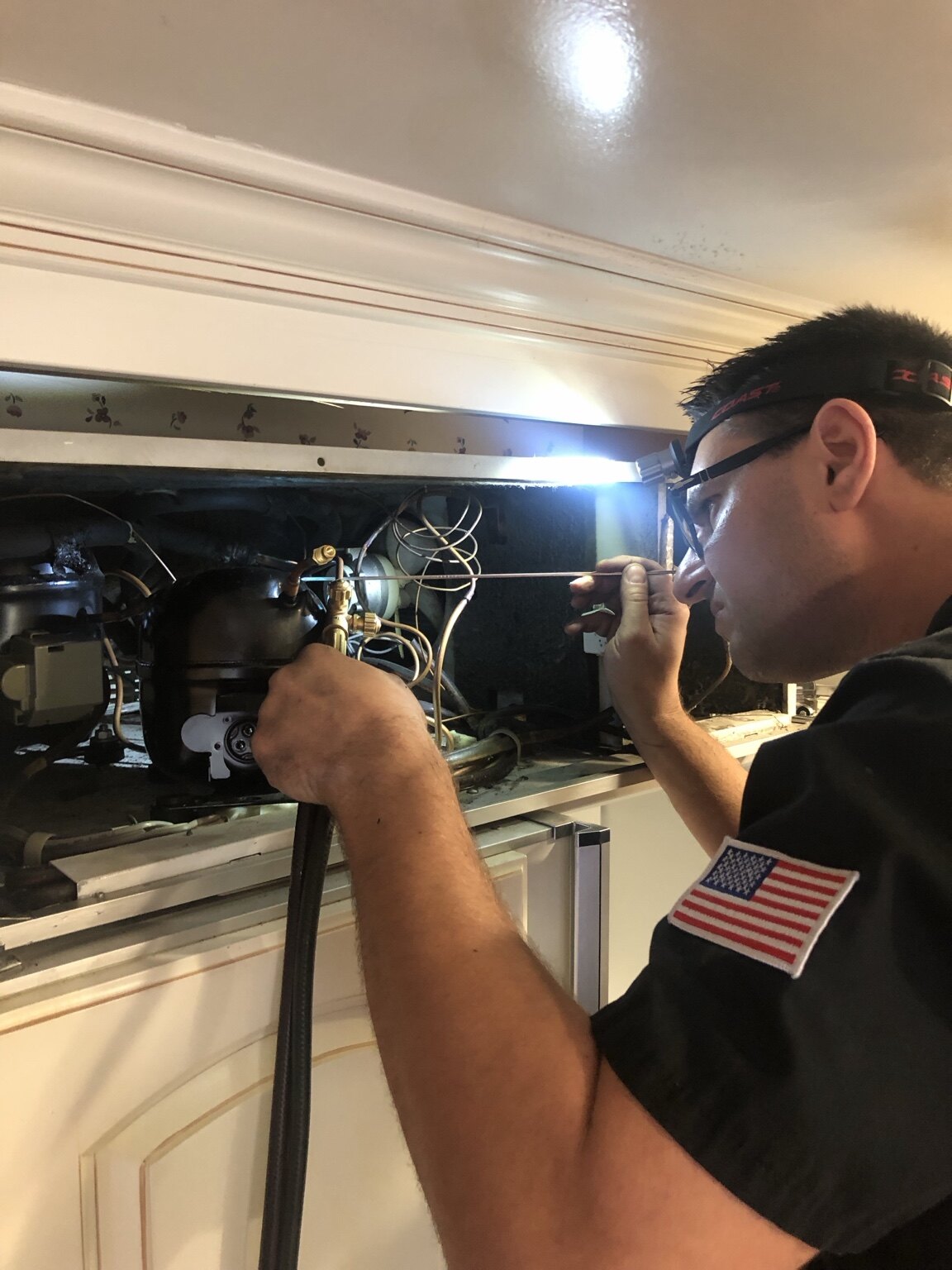 Technician diagnosing a built-in refrigeration system