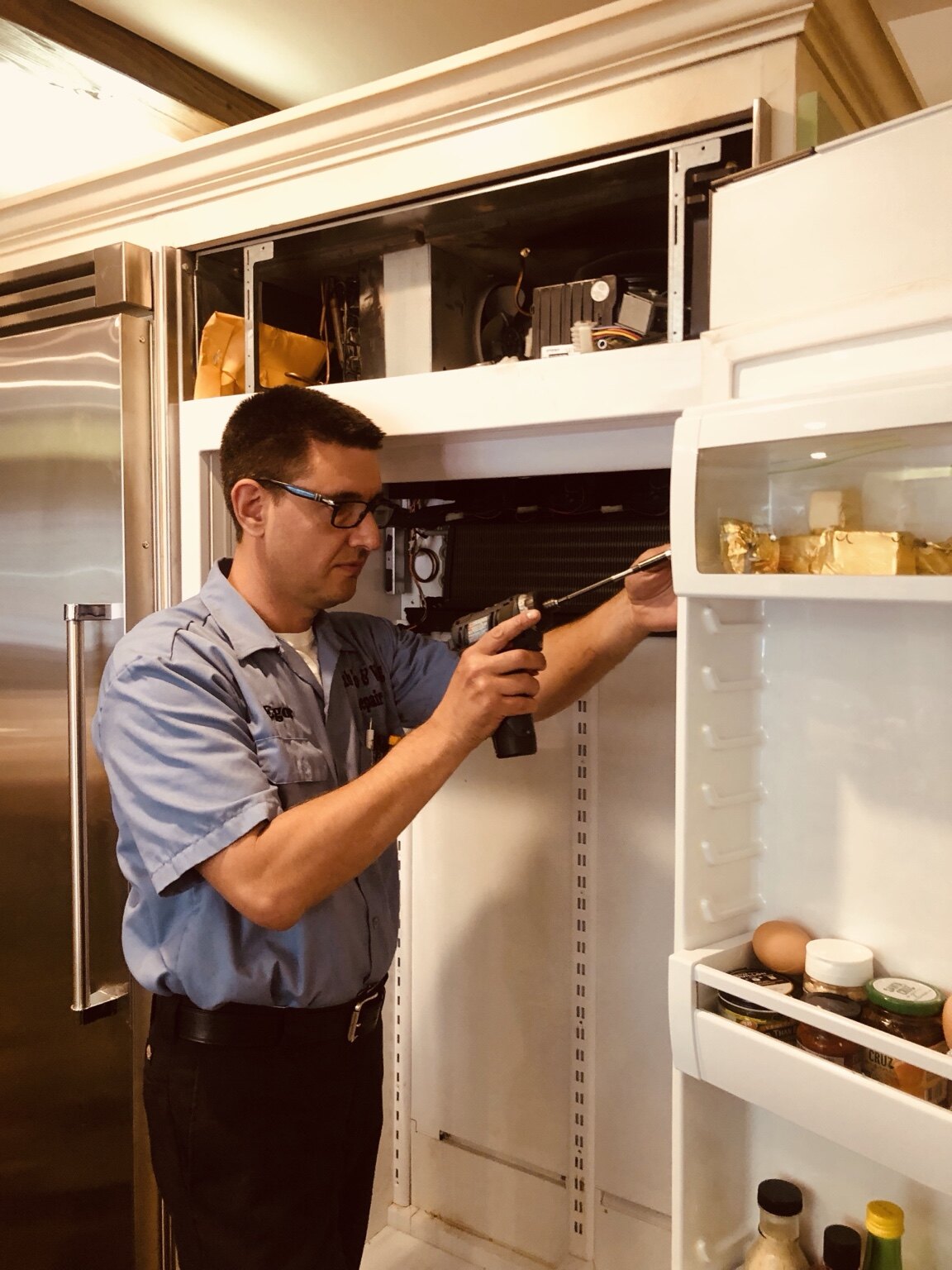 Technician servicing a built-in Sub-Zero refrigerator